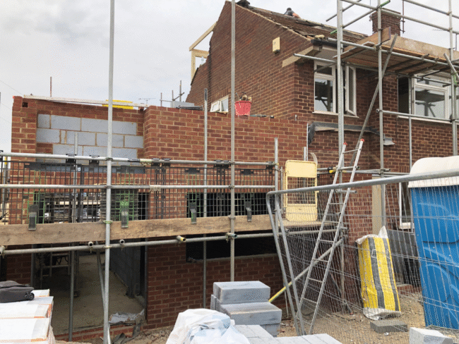 Modern UK home extension showing a mix of red brick and white render exterior, representing rising material costs and construction budgeting.
